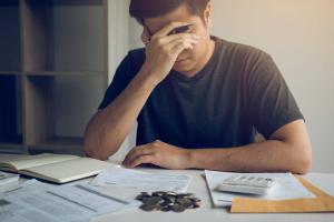 men are stressed about financial problems, with invoices and calculators